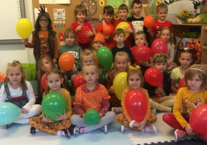 Dzieci pozują do zdjęcia trzymając balony